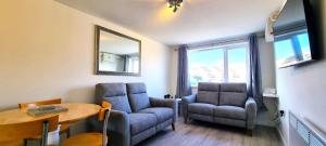 ein Wohnzimmer mit zwei Stühlen und einem Tisch in der Unterkunft 8 Penhale in Perranporth