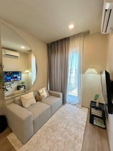 a living room with a couch and a large window at DLUX 7TH Floor in Ban Klang