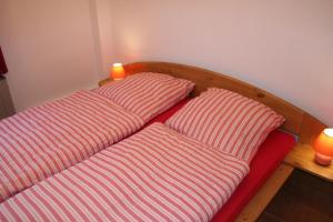 two pillows sitting on a red couch with two candles at Ferienhaus Maria Magdalena in Bad Lauterberg