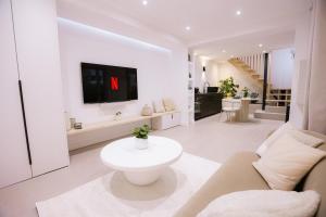 un soggiorno bianco con TV a parete di Sauna - Massage - Double Shower - Luxe in Romans a Romans-sur-Isère
