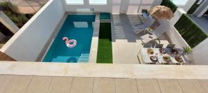 an overhead view of a swimming pool with people sitting at Casa LaryLen - with private pool and big solarium close to the beach and childfriendly! in Santiago de la Ribera