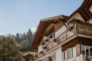 a large building with wooden balconies and windows at Hotel Berghaus Rosengarten - Culinary Hideaway in Nova Levante