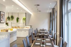 a restaurant with wooden tables and chairs and a counter at NH Collection Hamburg City in Hamburg