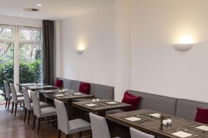a row of tables and chairs in a restaurant at NH Collection Hamburg City in Hamburg