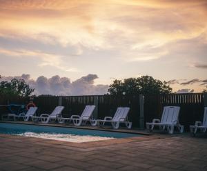 a group of chairs sitting next to a pool at Apartamenty Pod Dębami Stadnina Koni SPA Jezioro i Morze Sarbsk in Sarbsk