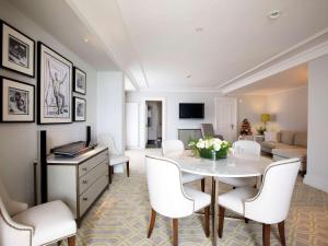 a living room with a table and white chairs at Fairmont Le Montreux Palace in Montreux