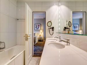 a white bathroom with a tub and a sink at Fairmont Le Montreux Palace in Montreux