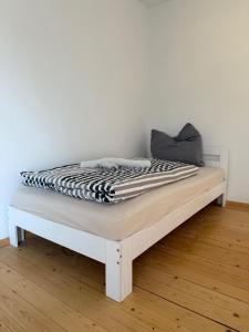 a bed with a black and white blanket on it at Monteur- und Ferienwohnung Landau - Südliche Weinstraße in Landau in der Pfalz +3 photos