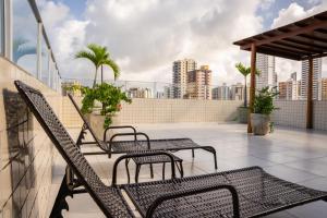 a patio with chairs and tables on a roof at Hotel Pousada Kairos Manaira in João Pessoa