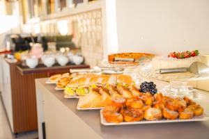 a buffet with several plates of food on a counter at Hotel Pousada Kairos Manaira in João Pessoa