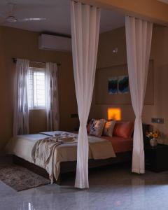 Moonlight Manor- Luxury Escape في بانغالور: غرفة نوم بسرير كبير مع ستائر