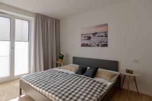 ein Schlafzimmer mit einem Bett mit einer karierten Decke darauf in der Unterkunft Ferienwohnung Strandlounge Schönberg - Kalifornien in Kalifornien