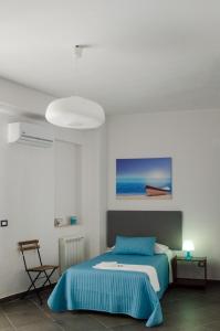 1 dormitorio con 1 cama y una pintura en la pared en B&B La Scala, en Realmonte