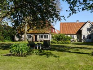 a house with two chairs and a table in a yard at Skyerne - Lütt Arnis in Arnis