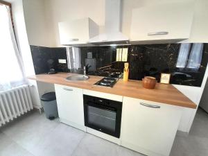 a kitchen with white cabinets and a sink and a stove at Élégant appartement Vatan centre in Vatan +14 photos