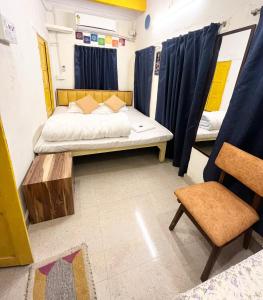 a small room with a bed and a chair at Kailash Heritage Homestay in Varanasi
