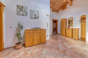 a large kitchen with wooden cabinets and a tile floor at Ferienwohnung "Familienglück" in Achslach