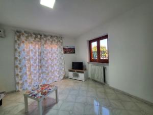 un soggiorno con un tavolo e una finestra di Casa in Piazza a Cinquefrondi