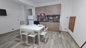 una cucina con un tavolo bianco e sedie bianche di Casa in Piazza a Cinquefrondi