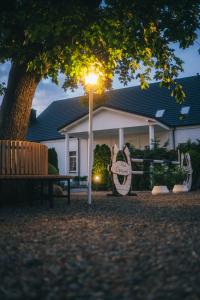 a light pole with a bench in front of a house at Apartamenty Pod Dębami in Sarbsk