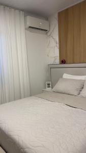 ein Schlafzimmer mit einem weißen Bett und einem Fenster in der Unterkunft Suite no centro de Doutor Pedrinho in Rio Forcação