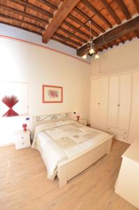 1 dormitorio con 1 cama grande y suelo de madera en Aida, en Lucca