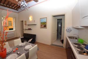 una cucina e un soggiorno con tavolo in una camera di Aida a Lucca