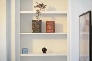 ein Bücherregal mit Büchern und einer Vase darauf in der Unterkunft High-End home, Free Parking, 3 beds, sleeps 5 in Ferryhill