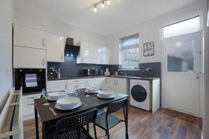 eine Küche mit einem Tisch und Stühlen sowie eine Küche mit einem Herd in der Unterkunft High-End home, Free Parking, 3 beds, sleeps 5 in Ferryhill