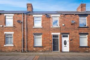 ein rotes Backsteingebäude mit weißen Türen und Fenstern in der Unterkunft High-End home, Free Parking, 3 beds, sleeps 5 in Ferryhill