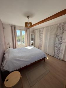 een slaapkamer met een bed, een tafel en een raam bij Mas de charme provencal in Cavaillon