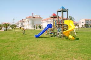 a playground with a slide in a park at Sadev Turizm Belek Family Villas in Belek