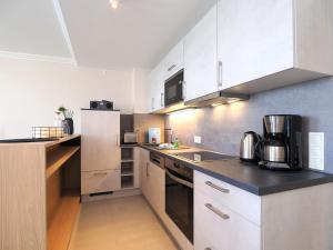 eine Küche mit weißen Schränken und einer schwarzen Arbeitsplatte in der Unterkunft Seehof Seehof 121 in Bansin + 9 Fotos