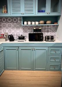 a kitchen with blue cabinets and a white counter top at Casa Gris with Shared Pool in Ban Bo Han