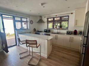a kitchen with a counter and a chair in it at Your Lake side Retreat Sleeps 10-12 Nr Park & Sea in Poole