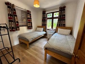 a bedroom with two beds and a window at Your Lake side Retreat Sleeps 10-12 Nr Park & Sea in Poole