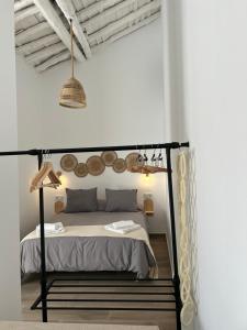 een slaapkamer met een zwart hemelbed in een witte kamer bij Casa Peñas 2 in Ronda