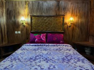 テテバトゥにあるSyaqila Homestay Lombokのベッドルーム(紫色の枕が付くベッド付)