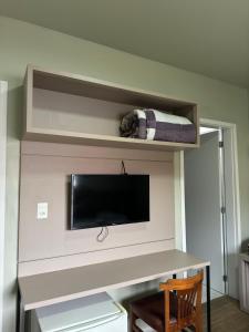 a room with a desk with a tv and a shelf at Hotel Pampas in Rio Negro +11 photos