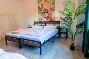 a bedroom with two beds and a painting on the wall at SHINYHOMEZ - Familienfreundliche Ferienwohnung in Geestland am Wattenmeer mit Terrasse, Küche und WLAN in Neuenwalde