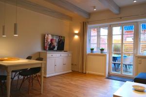 ein Wohnzimmer mit Tisch und Stühlen und einem Fenster in der Unterkunft Haus Boldix Whg 3 Barbados in Boldixum