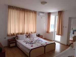 a bedroom with a large bed with flowers on it at Стаи за гости Ники in Nesebar