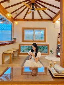 a woman sitting on a glass table in a room at Private house emotional accommodation, Hanok Stay Owol in Andong