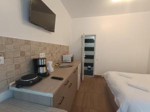 a bathroom with a counter with a sink and a bed at M20 Studios in Cluj-Napoca