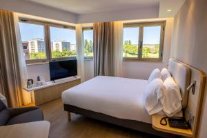 ein Hotelzimmer mit einem großen Bett und Fenstern in der Unterkunft Holiday Inn Express Logroño Rioja by IHG in Logroño