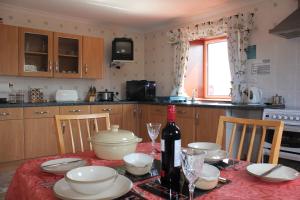 eine Küche mit einem Tisch und einer Flasche Wein in der Unterkunft Shiant View in Lochs