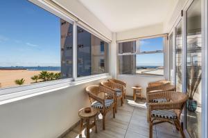 a balcony with chairs and windows looking out at the beach at Ocean Dream Sunset Sails in Swakopmund