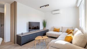 Una sala de estar con un sofá y un televisor. en Le Dauphiné 6 Allevard, en Allevard