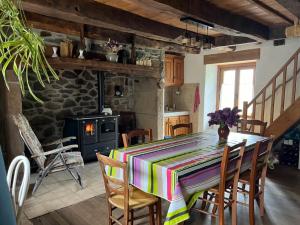 a dining room with a table and a fireplace at La Maison bleue in Le Monteil
