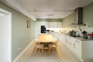a kitchen with a wooden table and chairs at Whatton Cottage in Gullane